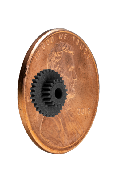 A 3D printed gear from DLP resin, placed on a penny for scale
