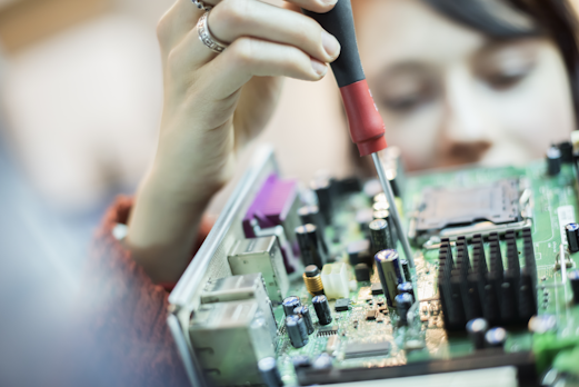 woman using a screwdriver on a computer chip