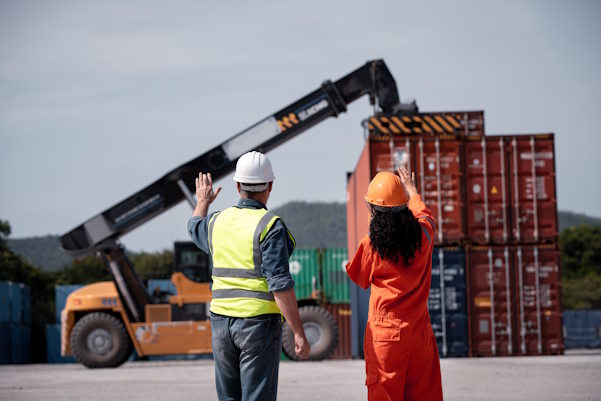 two workers watching a mobile crane in use