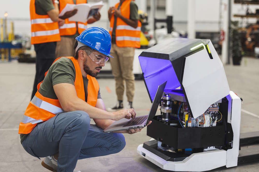 Worker programming an AGV in a warehouse