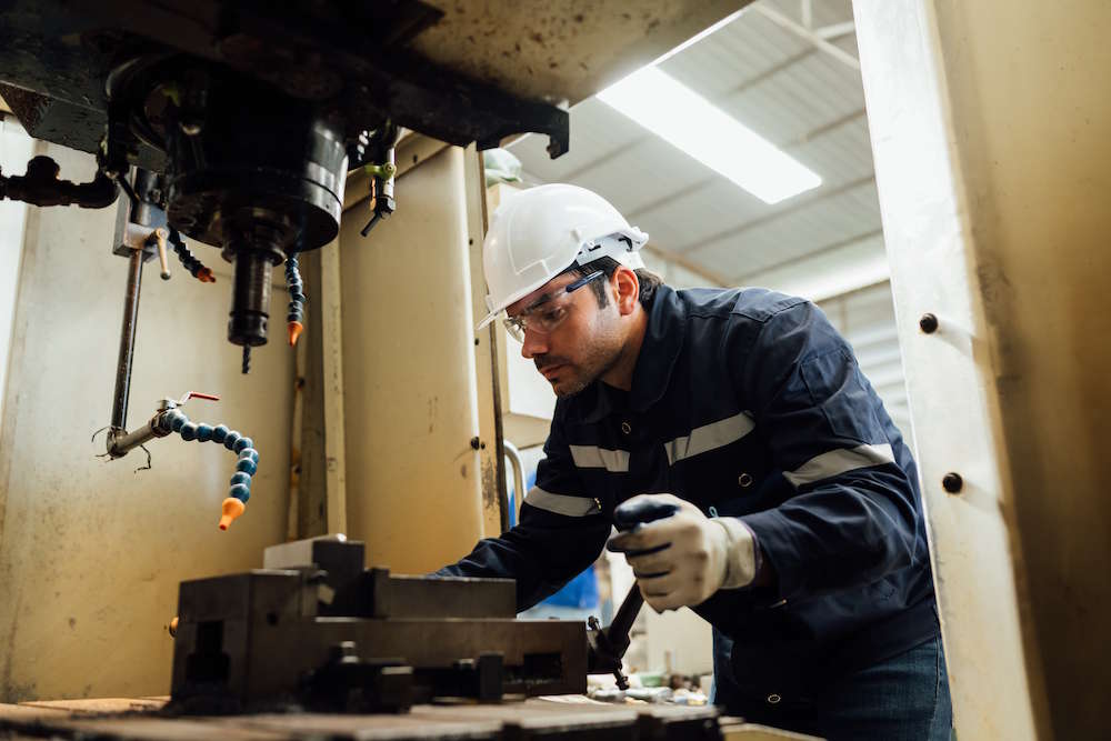 Worker performing maintenance on a machine tool